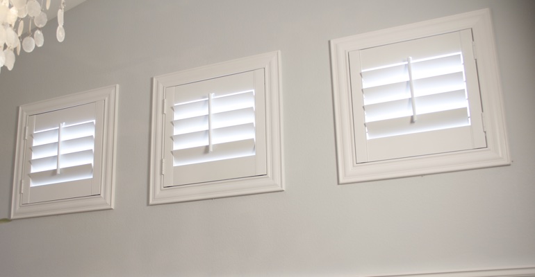 White shutters on square windows in laundry room